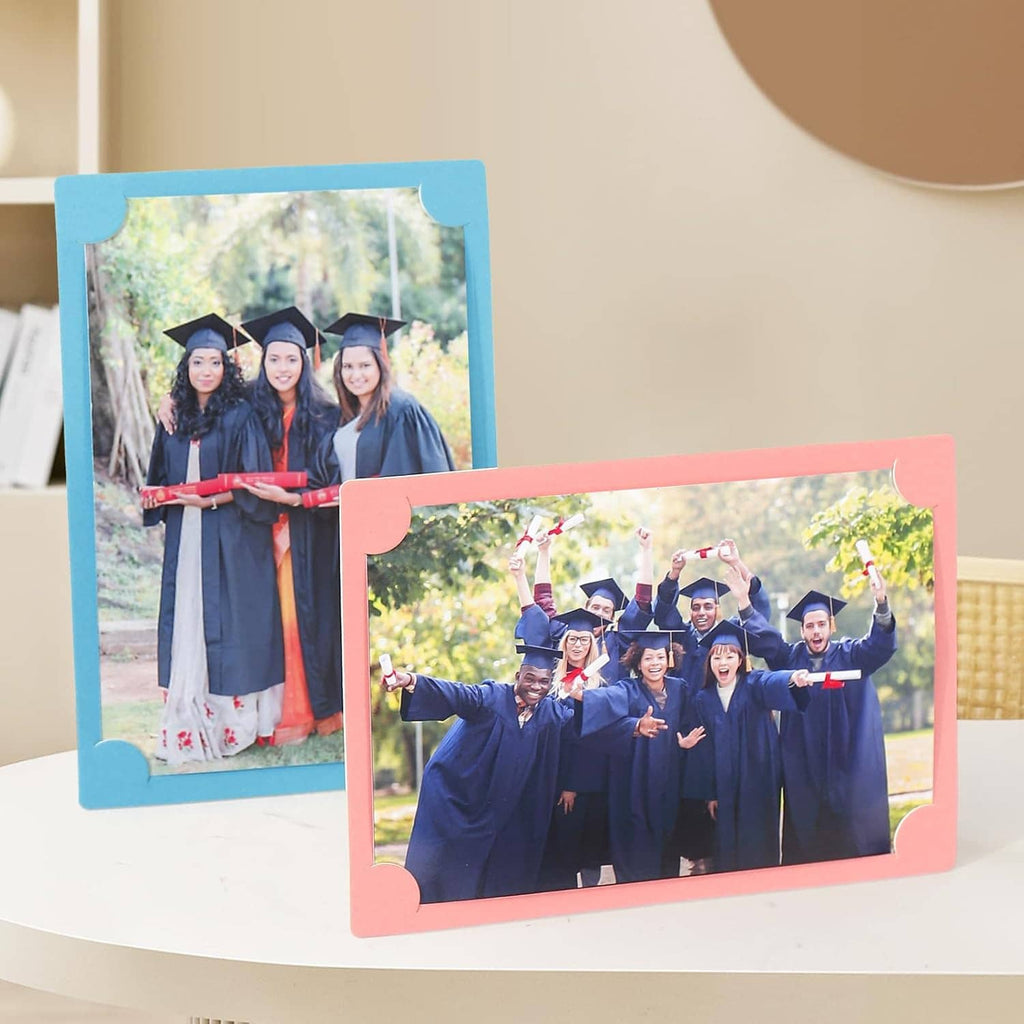 Two standing cardboard photo frames with easels, blue and pink borders, graduation portraits