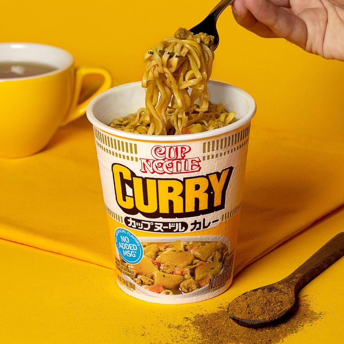 Curry instant ramen in white cup with visible noodles and toppings