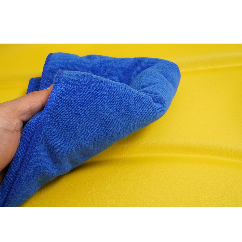 Tractor seat cushion being cleaned with a blue microfiber cloth on yellow surface