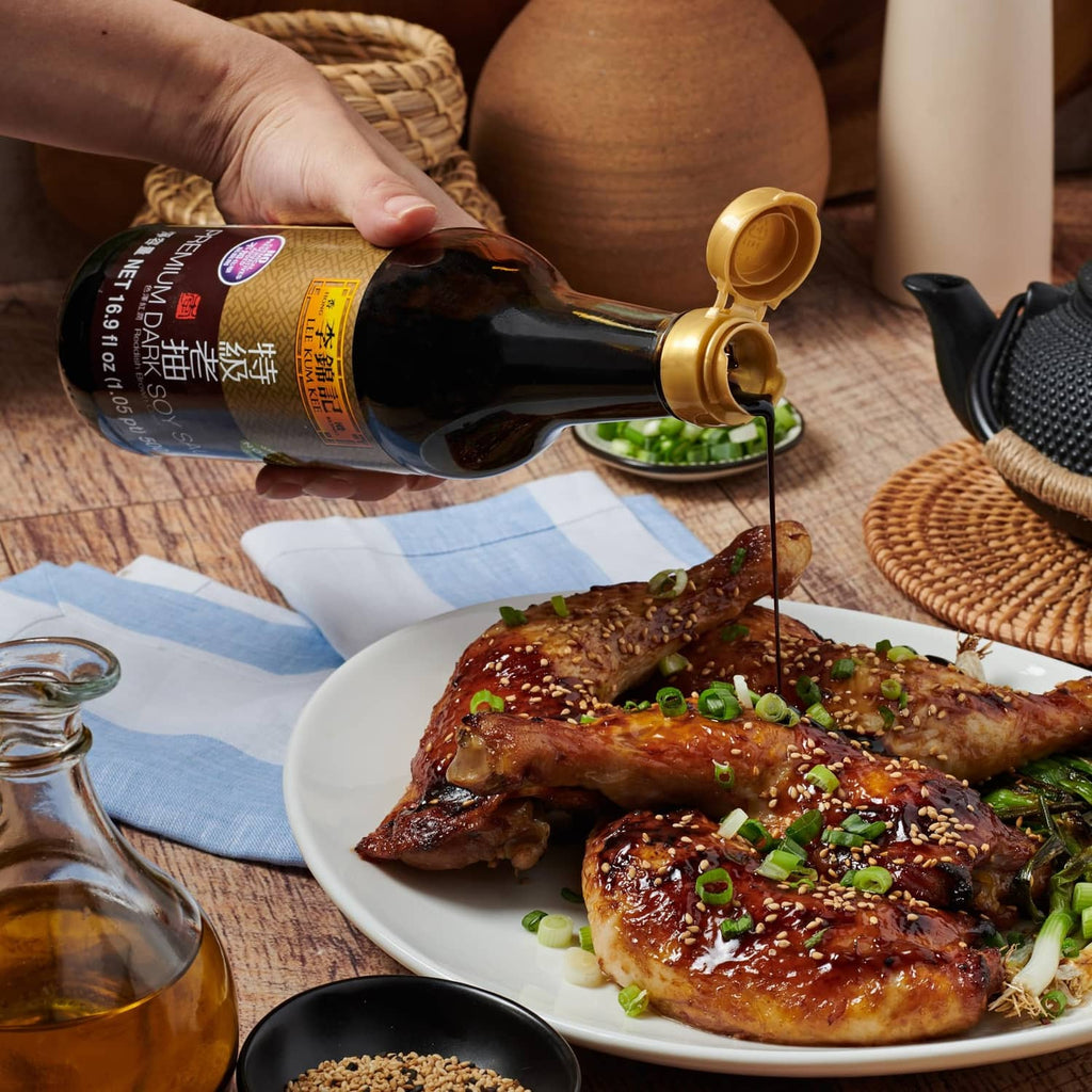 Lee Kum Kee dark soy sauce bottle being poured over grilled meat and greens