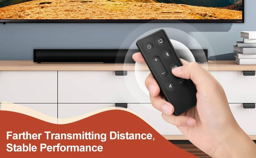Hand holding a black remote control in front of a soundbar