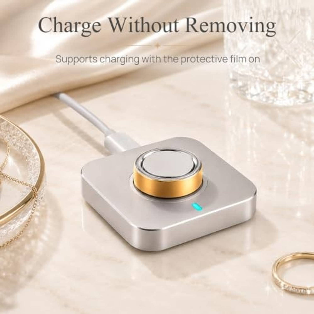 Oura ring with gold skin cover installed on a charging stand