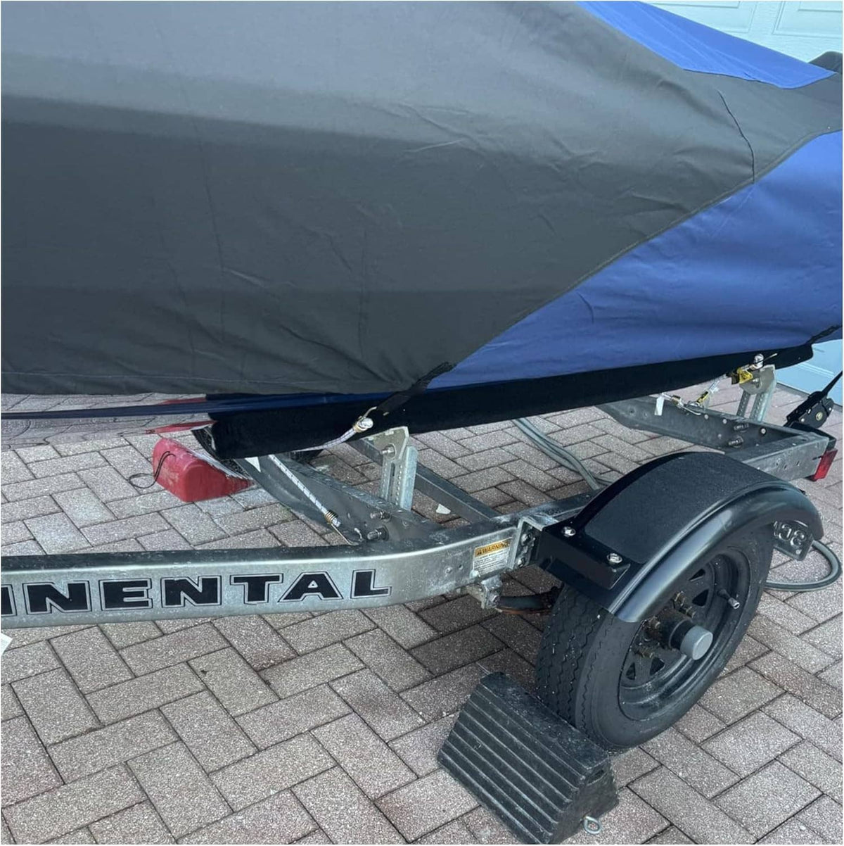 Black trailer fender installed near the wheel on a small utility trailer