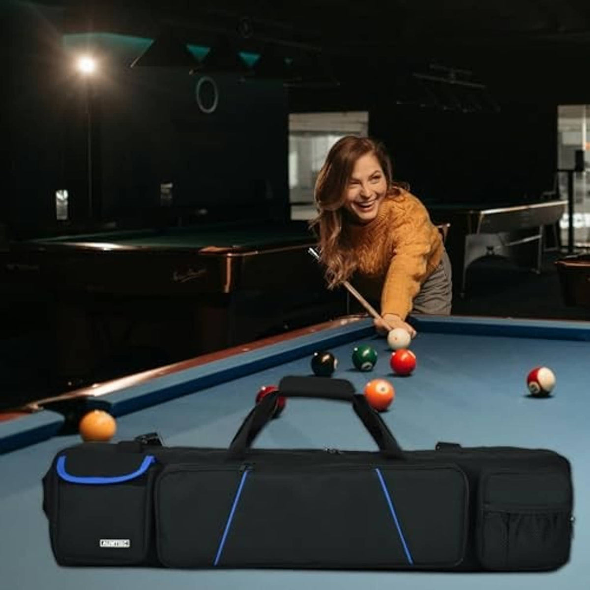 Black pool cue case bag with blue trim resting on a billiard table