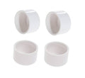 Set of four white PVC pipe end plug caps with open round interiors