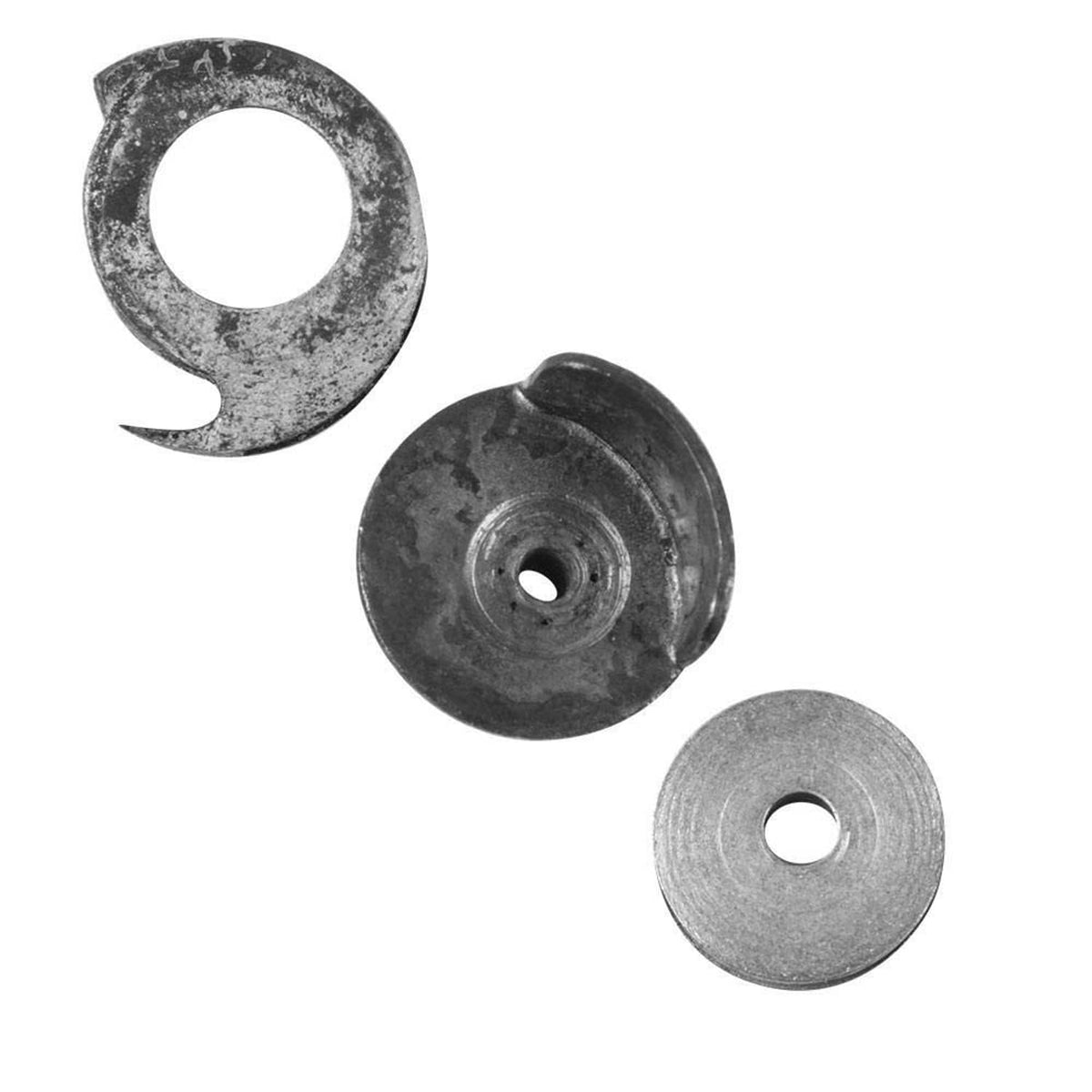 Close-up: dark bobbin case, dark chassis part, and light gray bobbin in a set