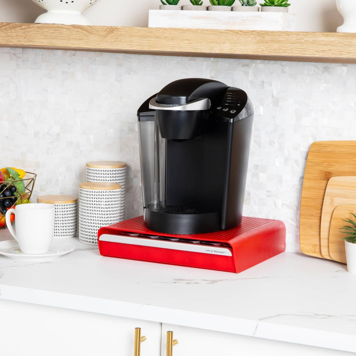 Red coffee pod drawer with black single-serve brewer resting on the top platform