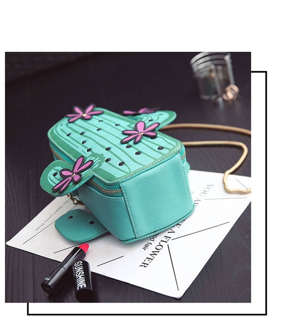 Teal cactus-shaped crossbody bag with purple flower appliques and gold zipper hardware