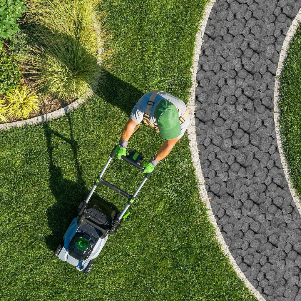 Black lava rock pathway stones along a landscaped lawn edge