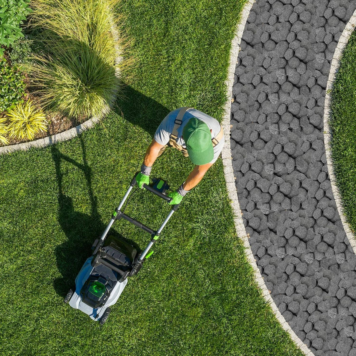 Black lava rock pathway stones along a landscaped lawn edge