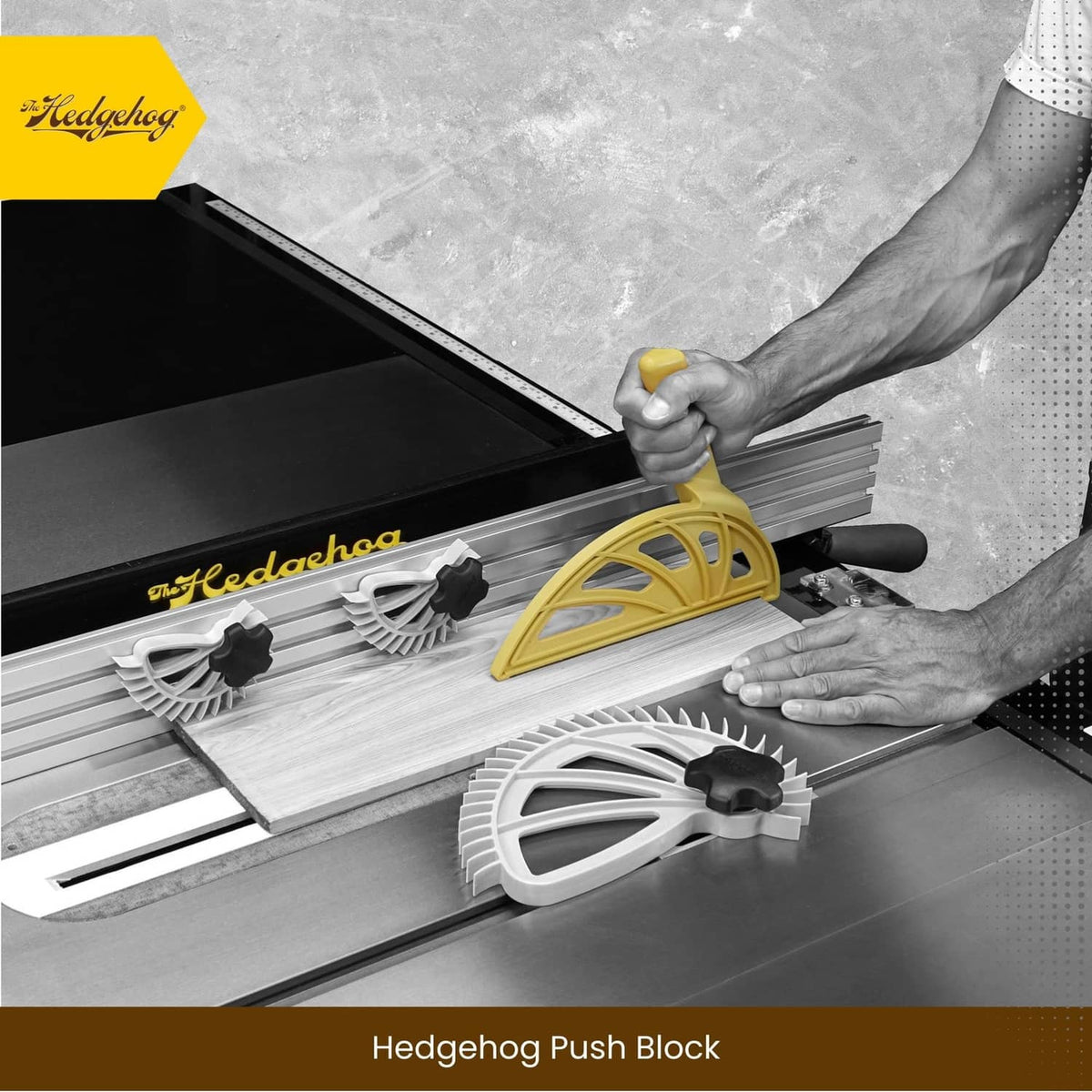 Yellow push block with wheel-style guard for safely moving a wooden board on a saw