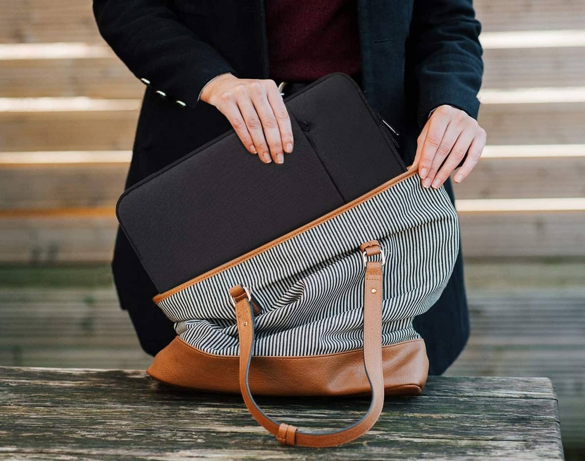 Black tablet sleeve with striped front pocket, carried by a person with handles