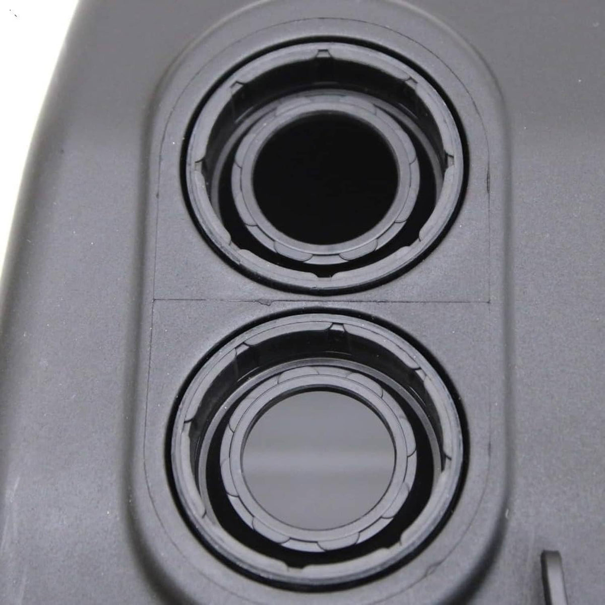 Valve cover gasket sealing rings around two circular openings on the black cover