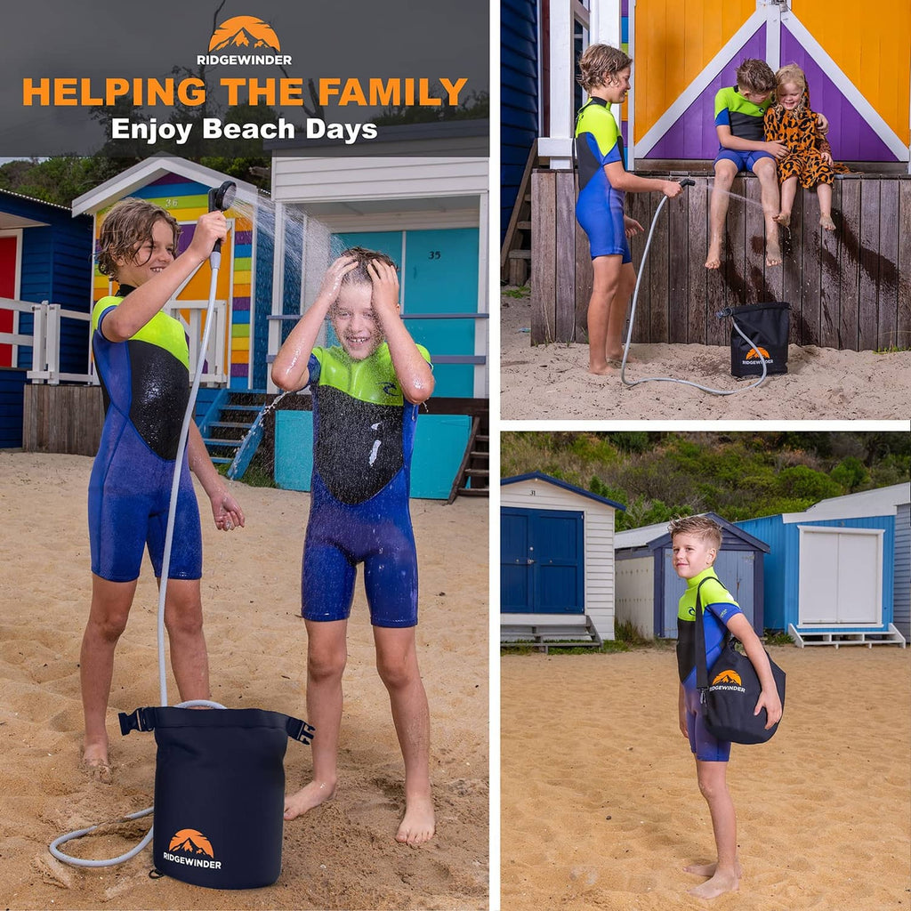 Portable camp shower dry bag with carrying straps and attached hose shown in beach use