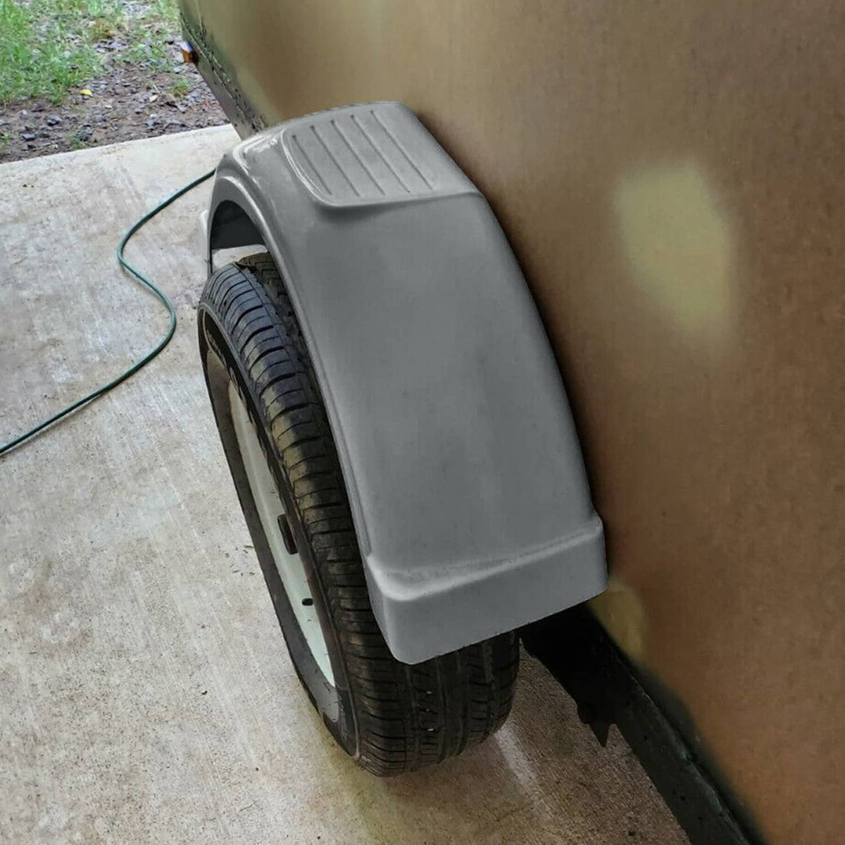 Installed gray plastic wheel fender on single axle trailer, covering tire top
