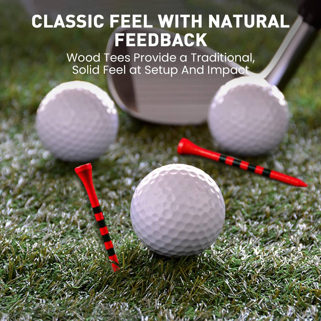 Red golf tees with black striped shafts on grass near three white golf balls