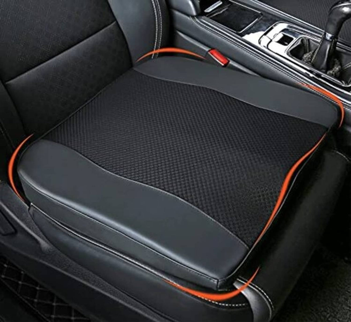 Black seat cushion with padded side bolsters, mesh center, and orange trim
