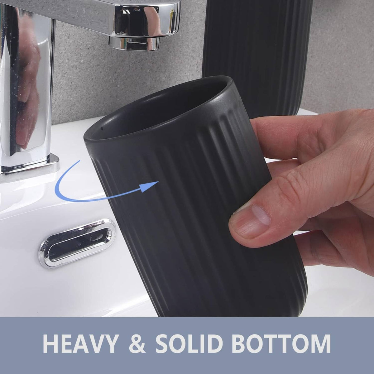 Matte black ceramic toothbrush holder held in hand, showing ribbed texture and open top