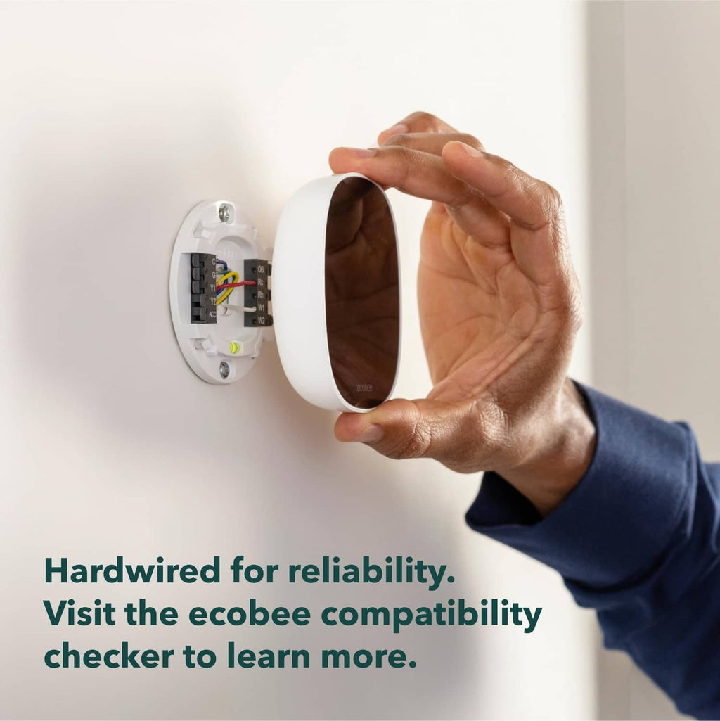 Hand placing a white thermostat cover over wall wiring