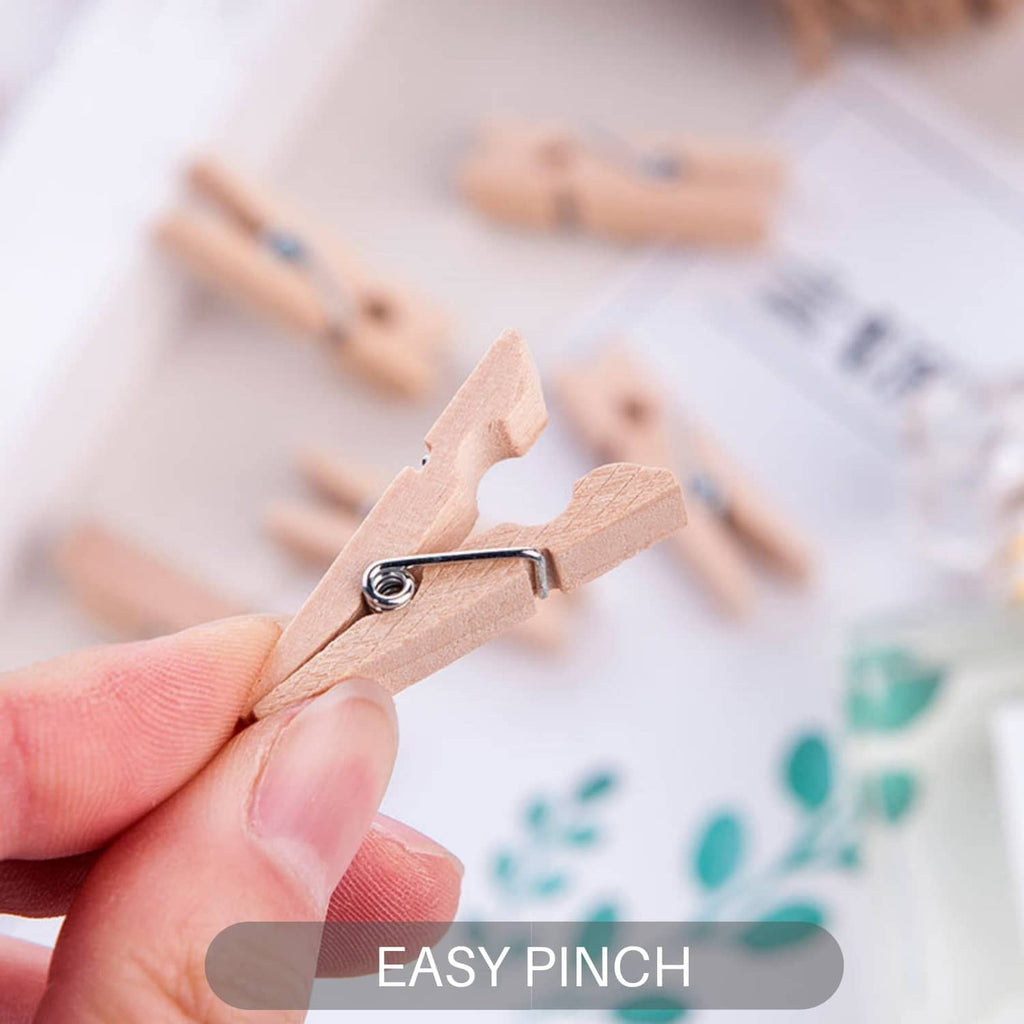 Hand holding a wooden mini clothespin with metal spring for easy clipping