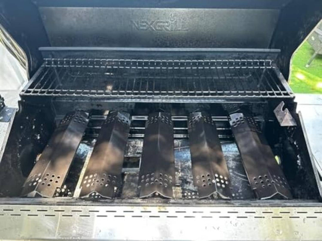 Grill burner heat plates installed inside a grill firebox, dark porcelain bars