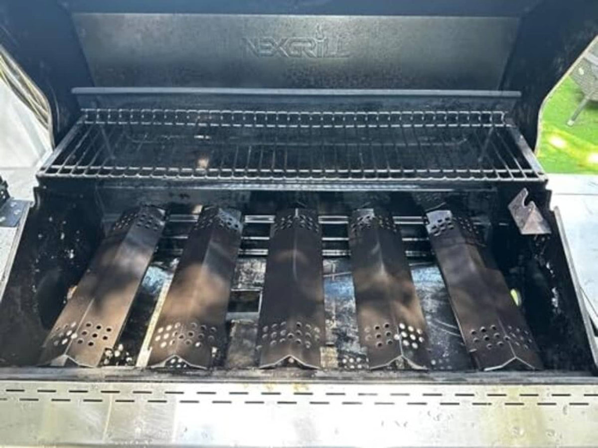 Grill burner heat plates installed inside a grill firebox, dark porcelain bars