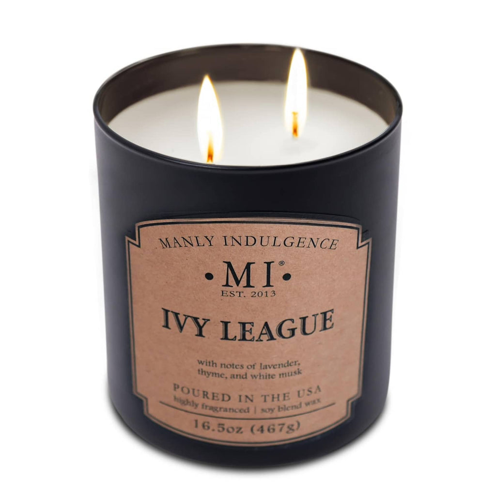 Lit black scented candle jar with warm flames and kraft 'Ivy League' label