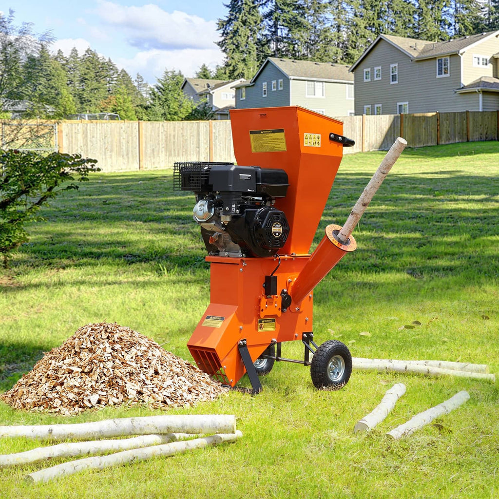 Orange wood chipper shredder mulcher feeding branches through side chute