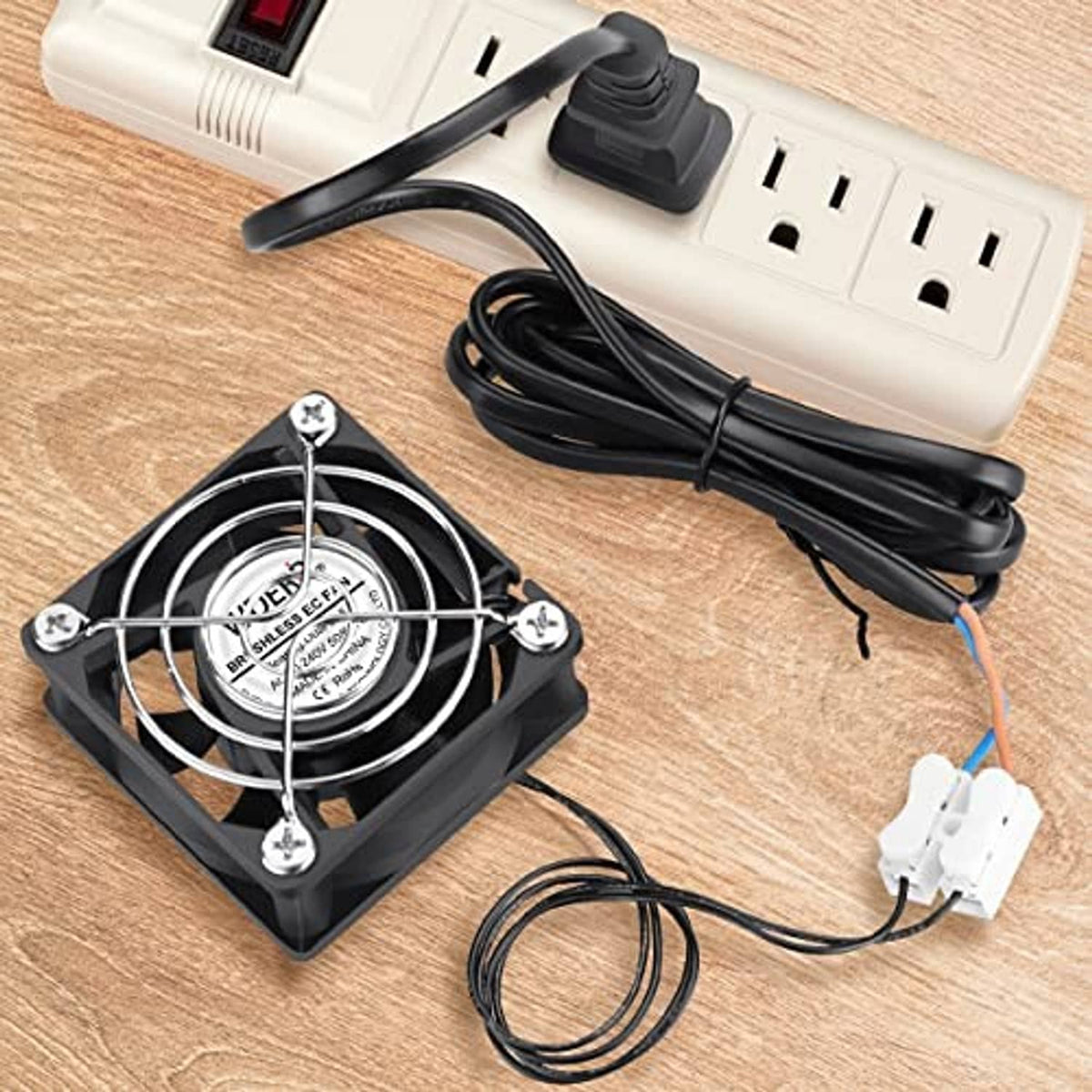 Square EC axial fan with two-prong plug and wiring harness on a wooden surface