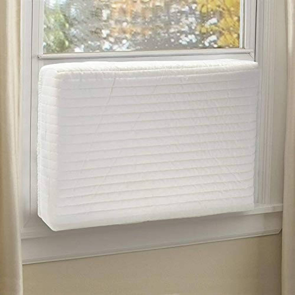 Cream quilted AC cover with padded panels, fitted for a small indoor unit.