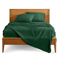 Forest green bed linen set with fitted sheet and pillowcases on full-size bed