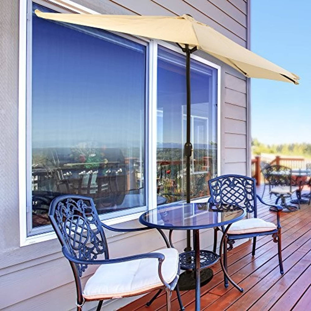Tan half-round patio umbrella open over outdoor table and chairs