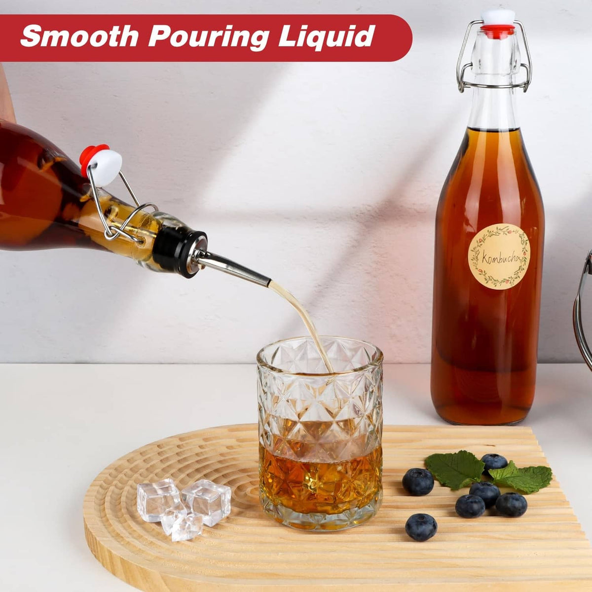 Clear glass swing-top bottle with red flip cap; amber liquid pouring into patterned cup