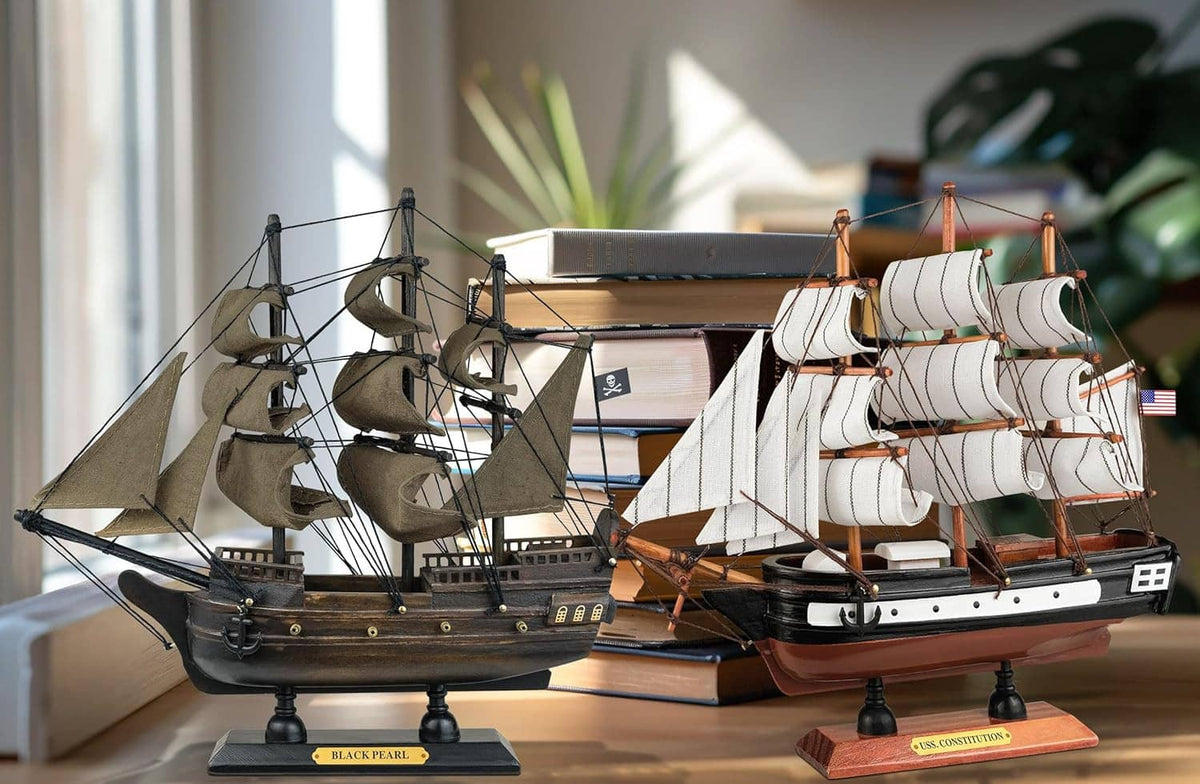 Pair of wooden ship models on stands, dark pirate ship and white sailing ship
