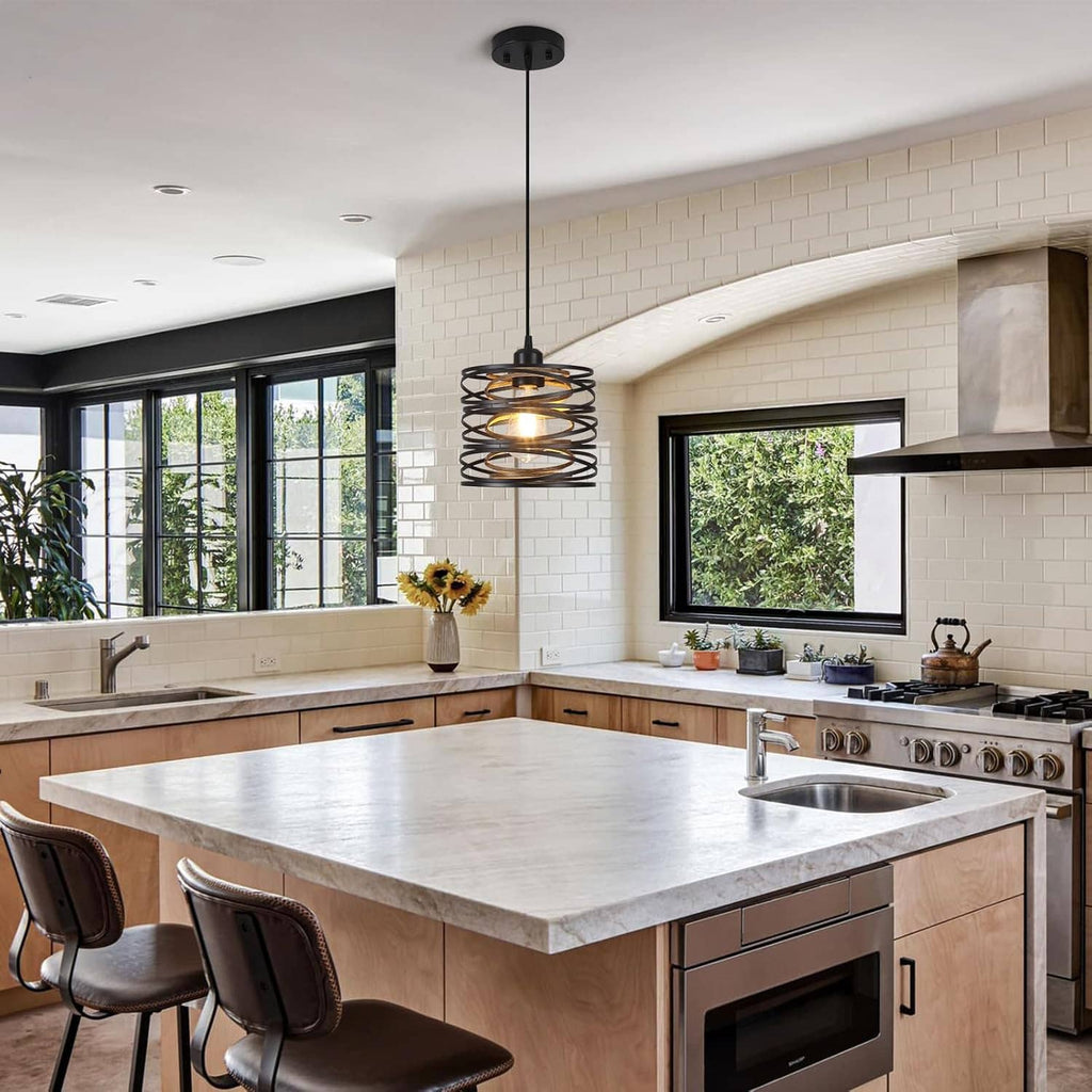 Black spiral cage pendant light hanging over a large kitchen island