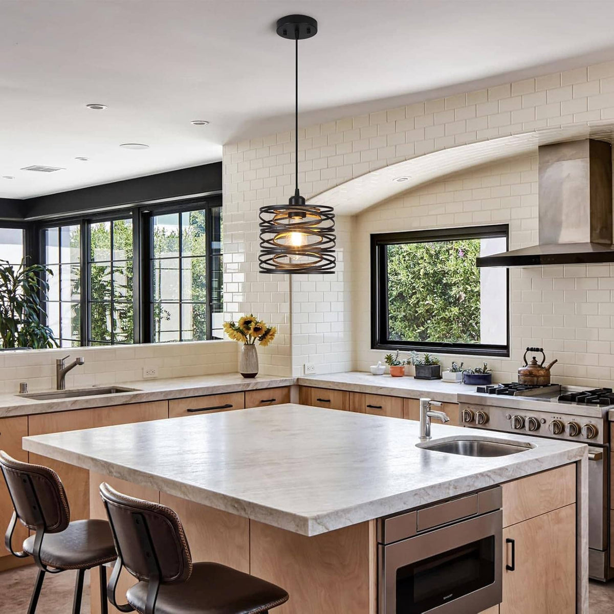 Black spiral cage pendant light hanging over a large kitchen island
