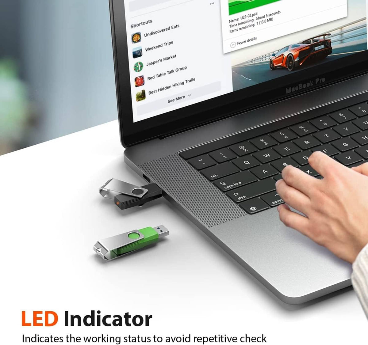Green LED USB flash drive plugged into laptop, hand inserting the thumb drive