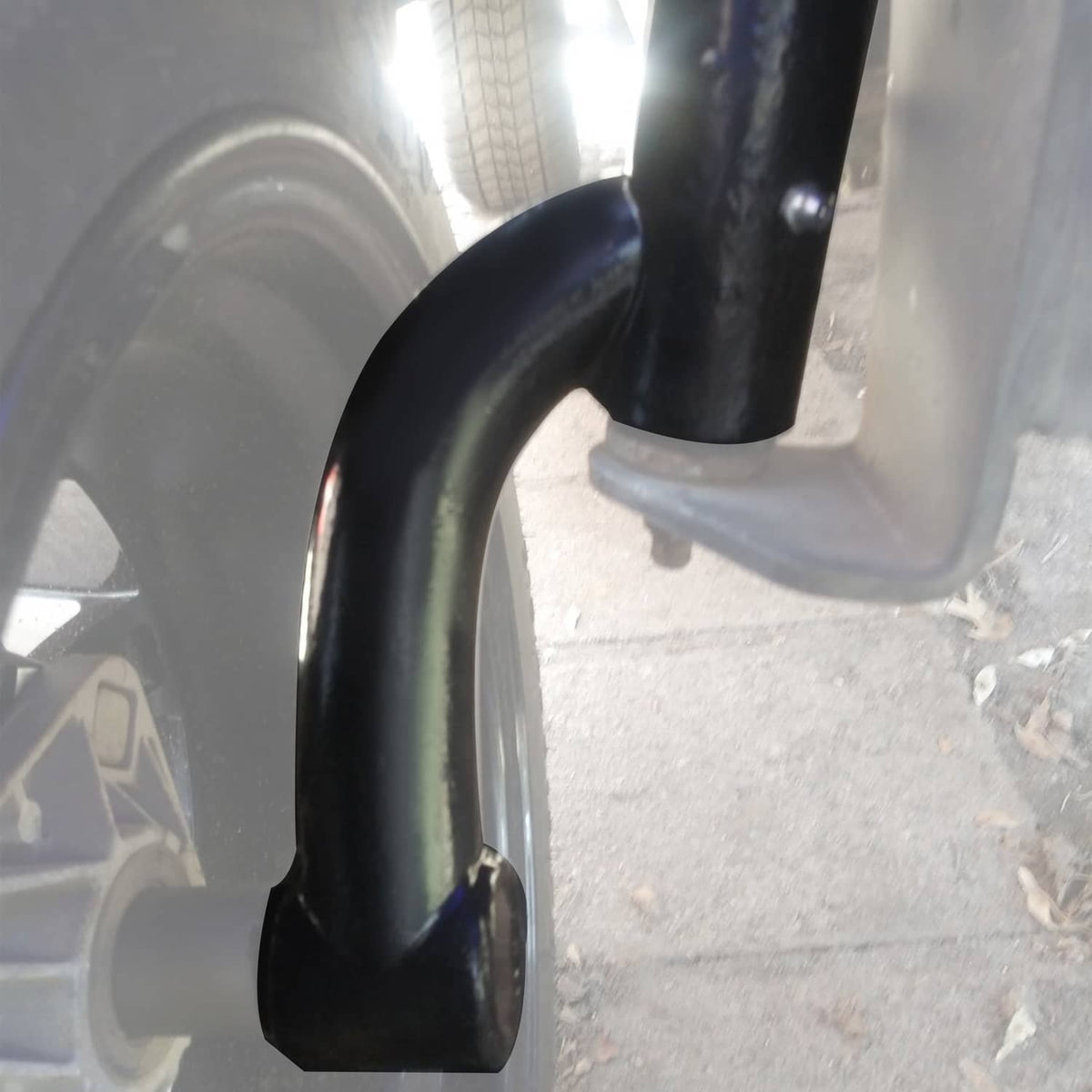 Installed black curved support arm and bracket near front wheel on golf cart frame