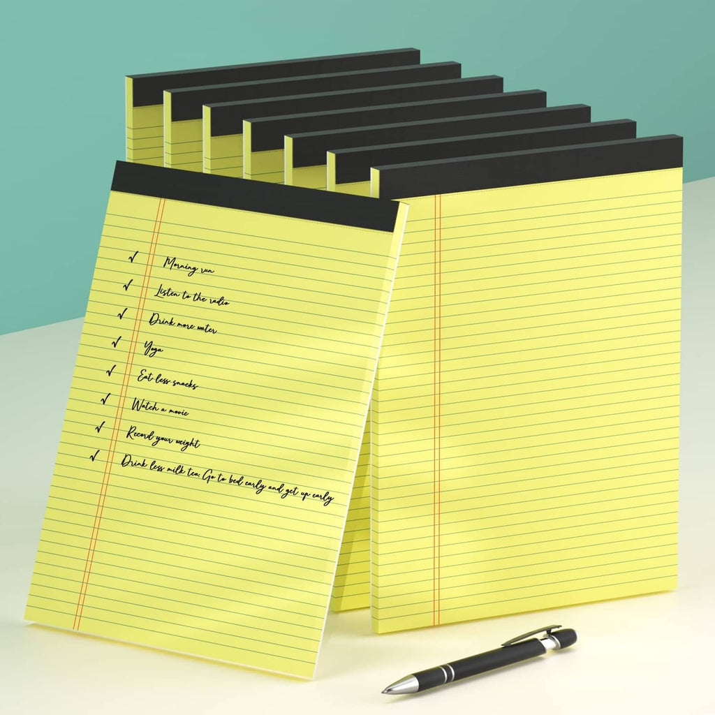 Stack of yellow legal pads with handwritten list on lined pages, black spines