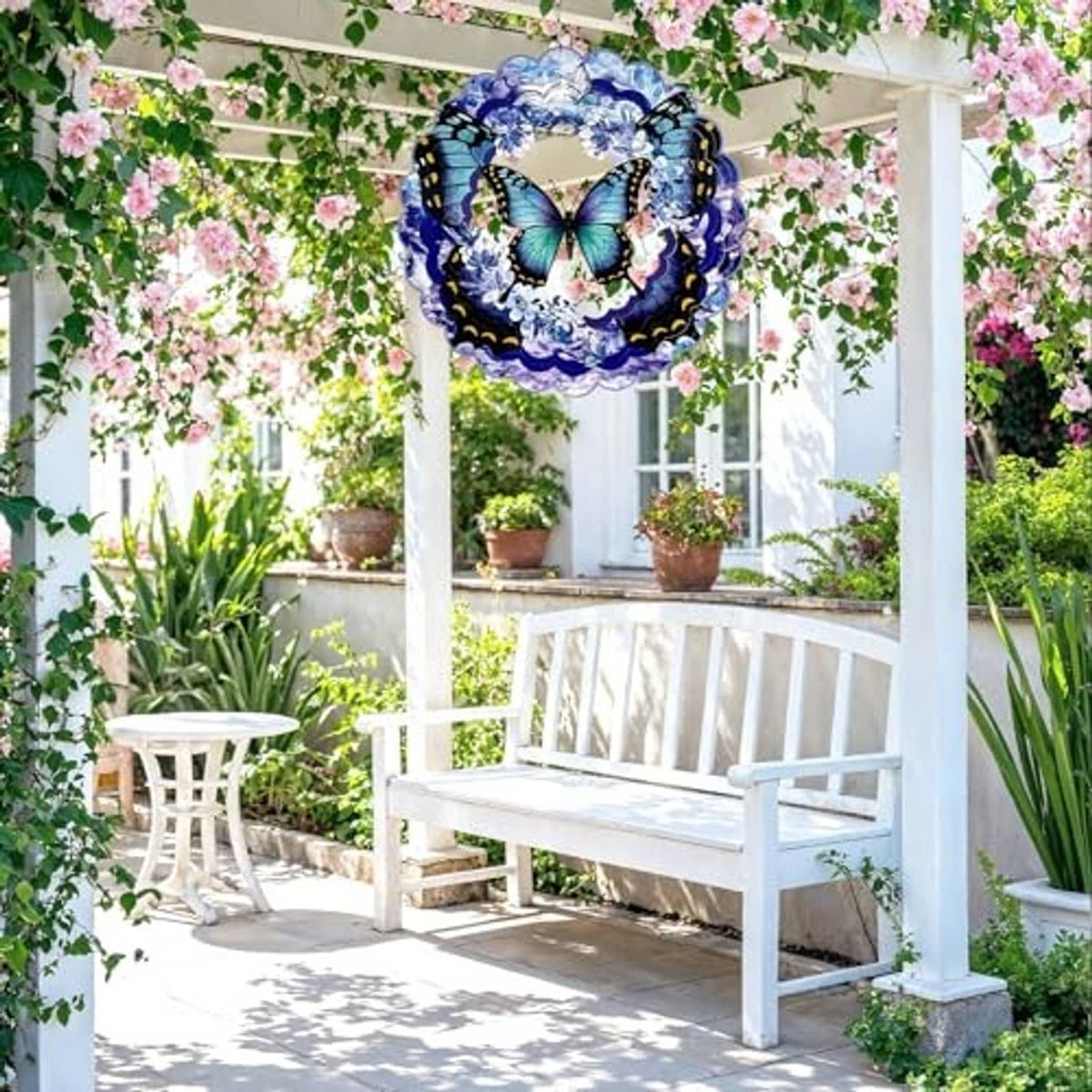 Butterfly wind spinner hanging on porch, blue and silver scalloped metal ring design