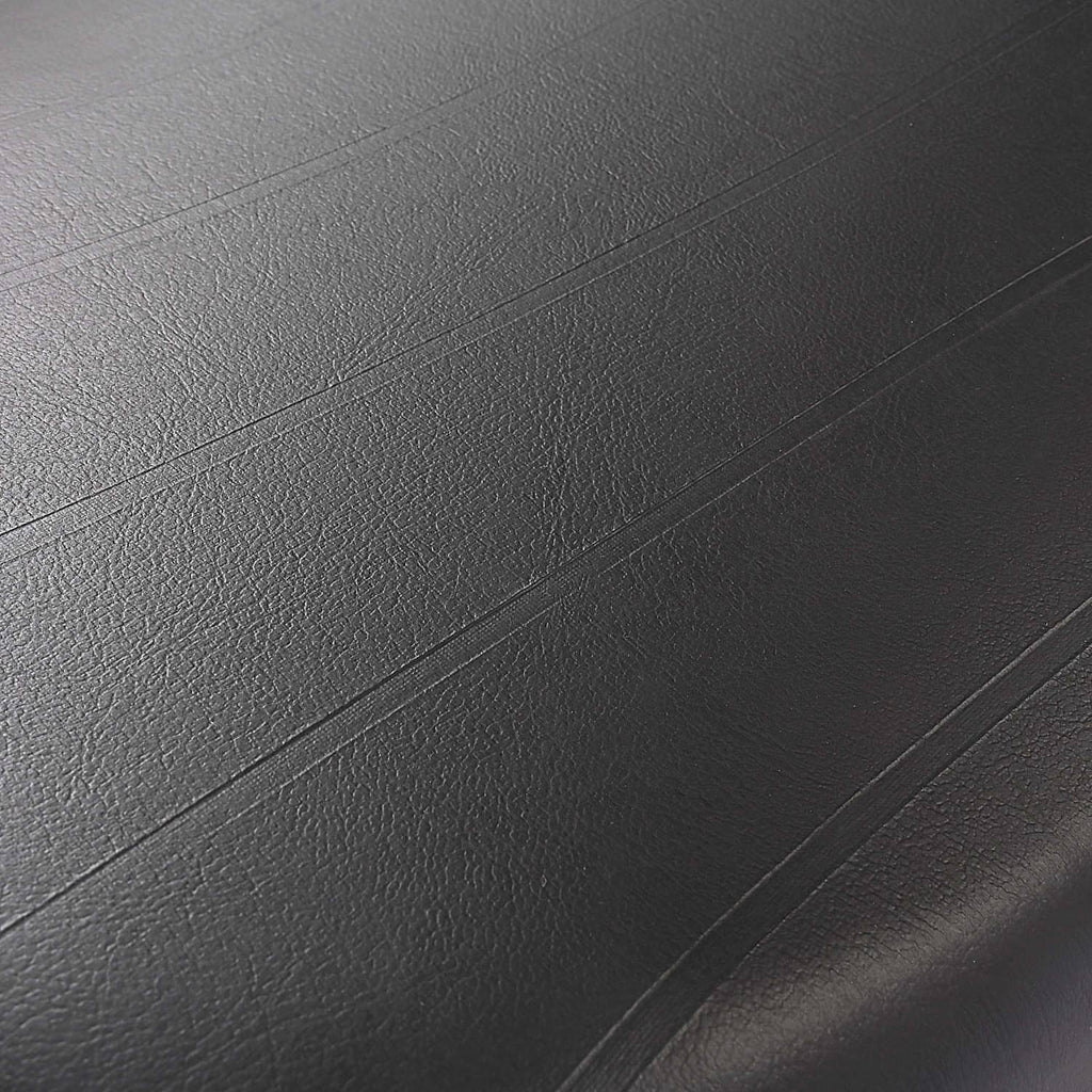 Black cushion close-up highlighting fine grain texture and horizontal stitched lines