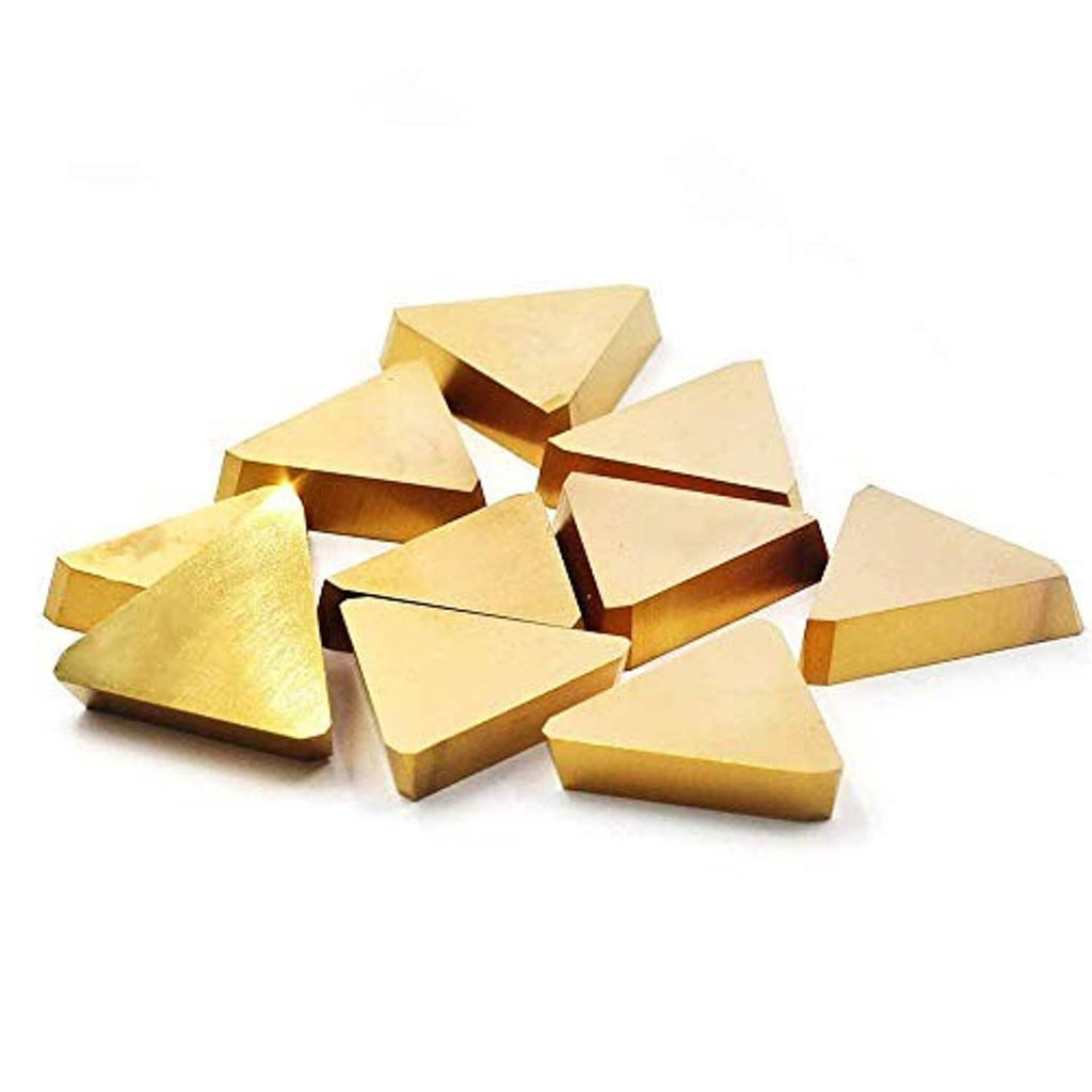 Assorted triangular carbide inserts, gold-toned coated surfaces, overlapping pile