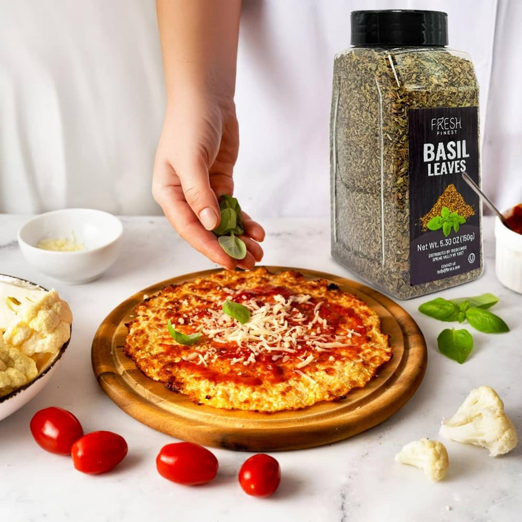 Dried basil leaves jar beside a pizza topped with basil leaves