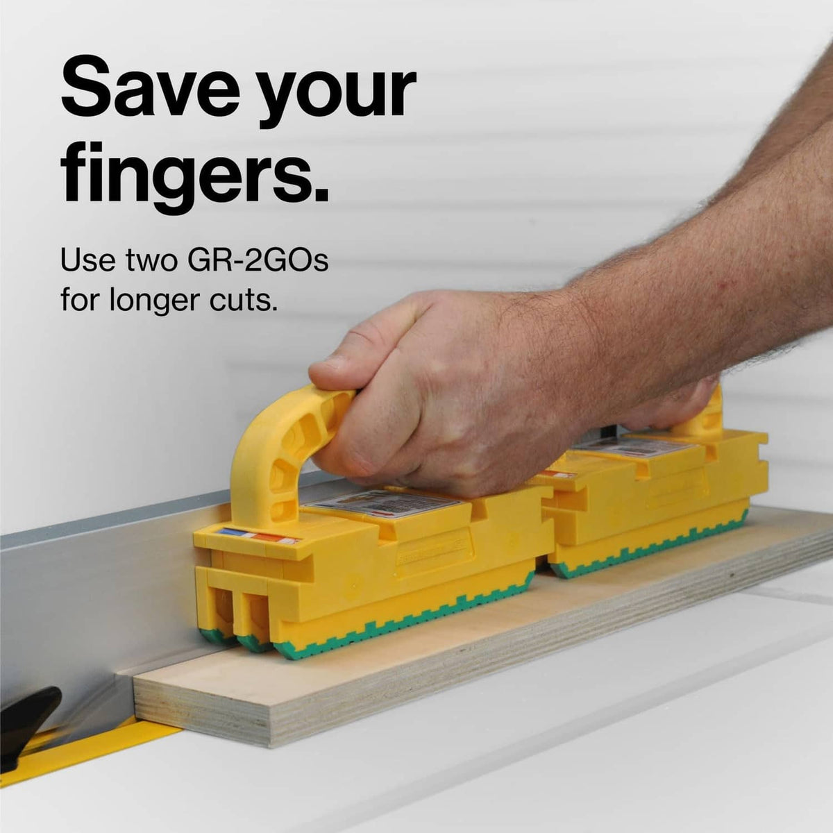 Two yellow router push blocks on fence with green toothed pads visible