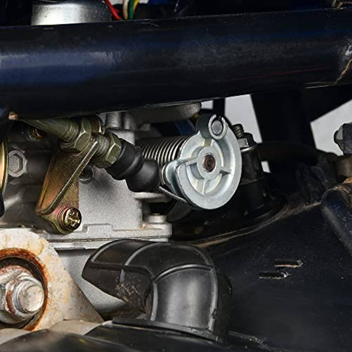 ATV cable connection near engine with throttle linkage and metal hardware