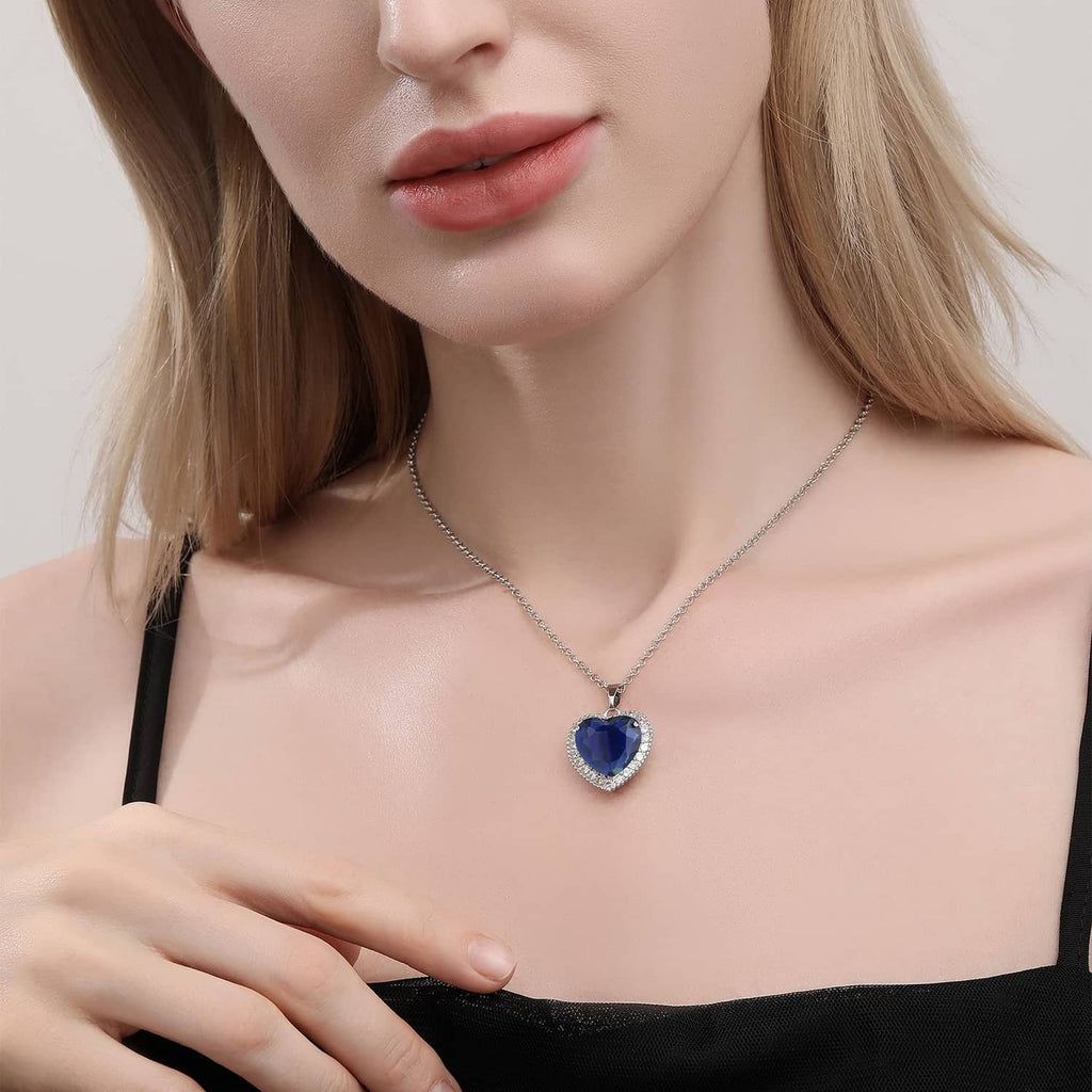 Heart gemstone pendant necklace in silver-tone chain on person’s neckline