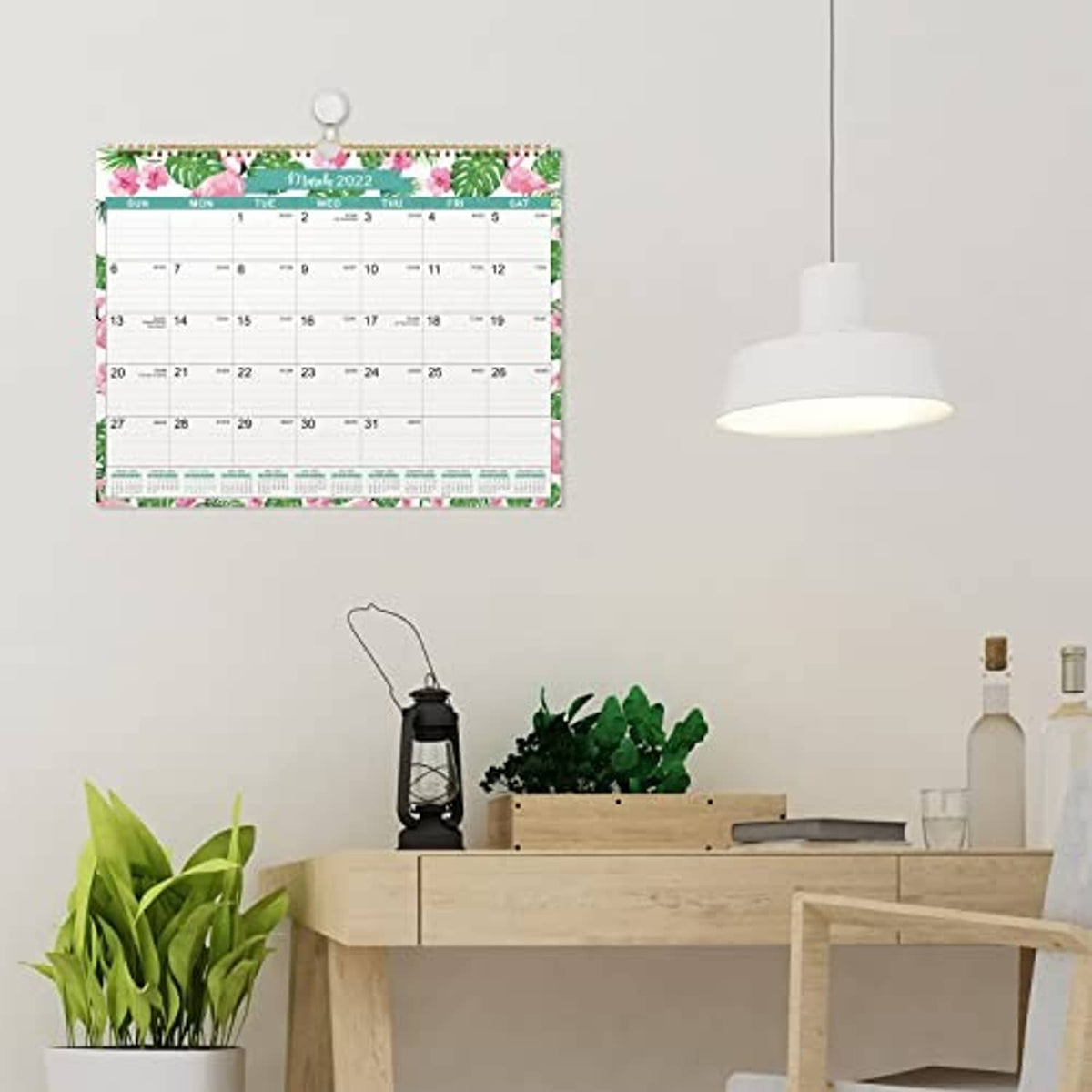 Hanging wall calendar showing February 2022 with cactus floral border and gold binding