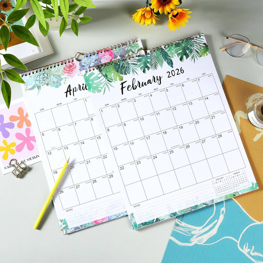 Floral monthly wall calendars laid on a table, showing April 2026 and February 2026