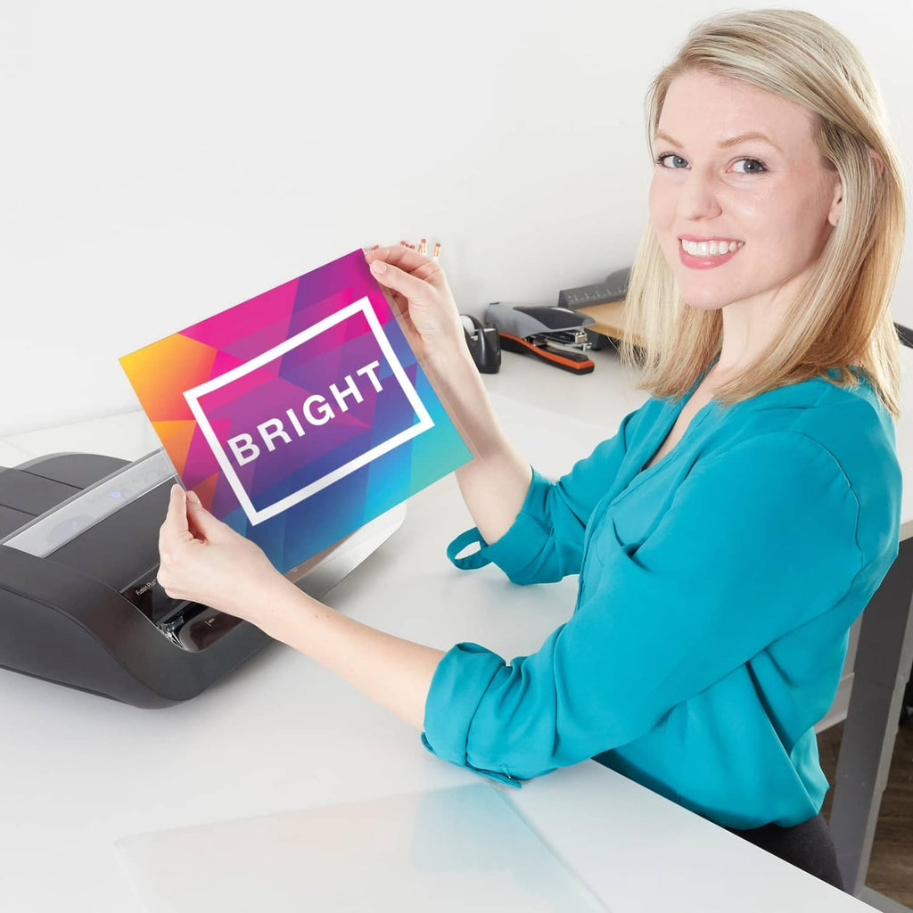 Clear laminating pouch with 'BRIGHT' graphic being fed into a laminator