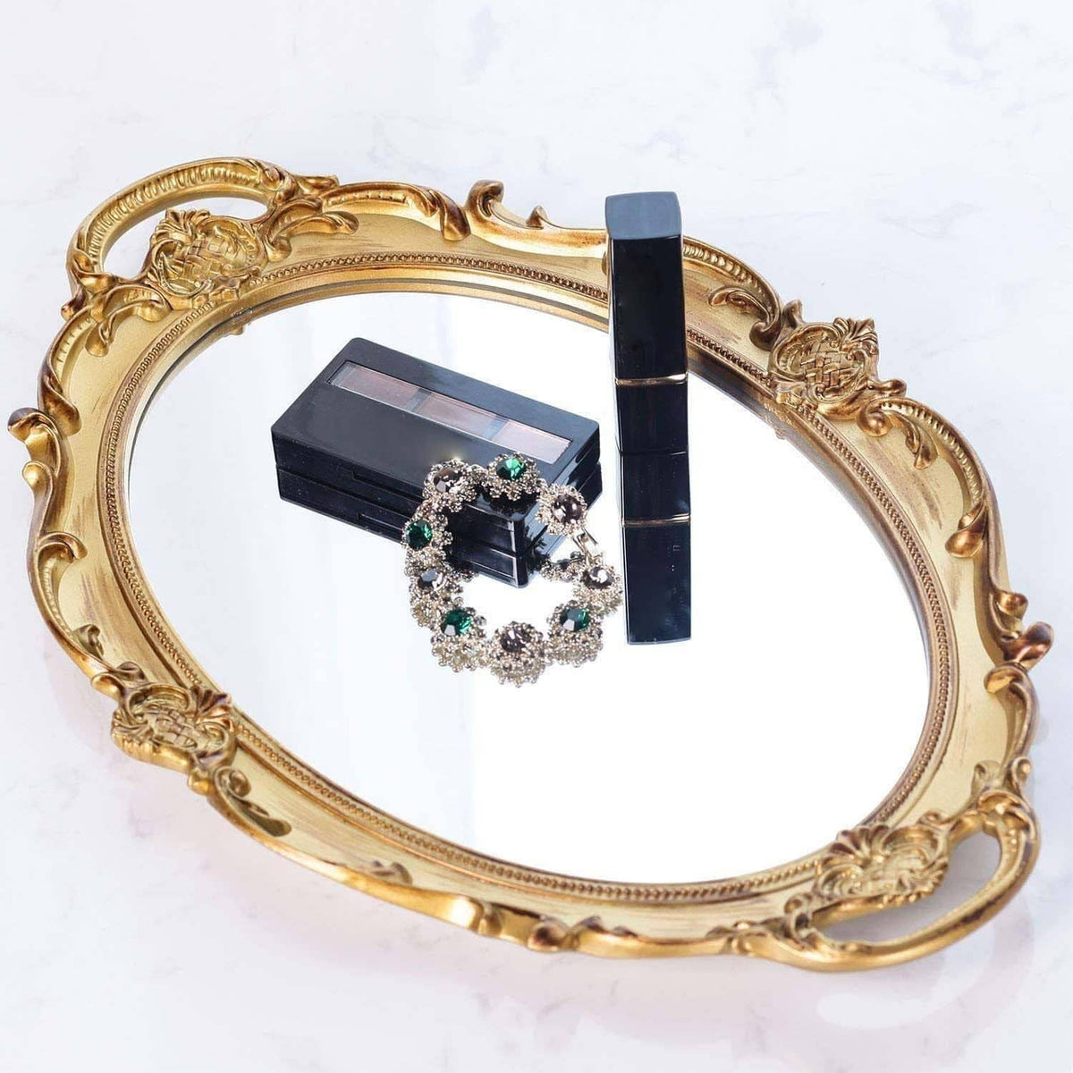 Gold oval decorative tray with jewelry box, earrings, and gemstone bracelet